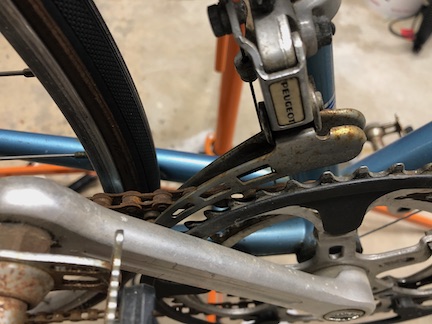 There's a pretty nice Stronglight crankset, with a functional plastic chainguard. A Peugeot-branded Simplex derailleur handles shifting. It should clean up OK. The very rusty chain, however, is a goner.